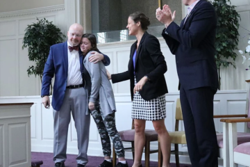 Dan Renaud, director of the River Oaks Center, embraces one of his students in the program during the ribbon-cutting ceremony.
