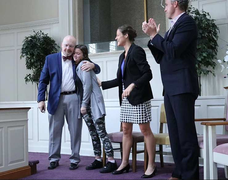 Dan Renaud, director of the River Oaks Center, embraces one of his students in the program during the ribbon-cutting ceremony.