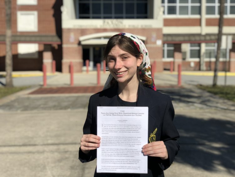 High School students holds TIME Magazine article.