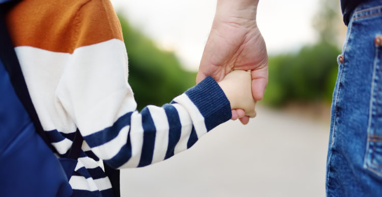 Stock photo of parent and child hand in hand