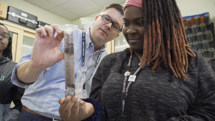 Photo shows Dr. Sowell assisting a student with lab work.