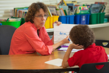 GRASP educator works with student in classroom.