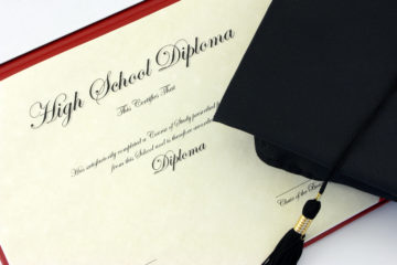 High school diploma and black cap with tassle