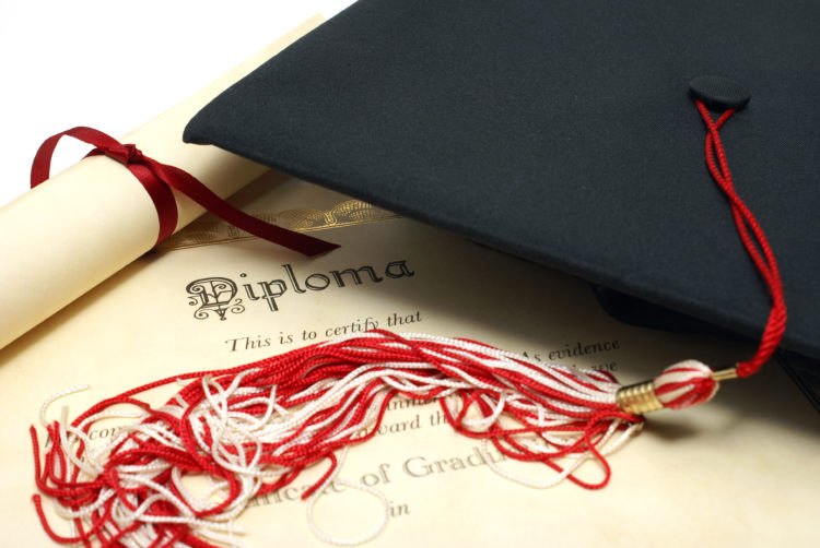 Photo of a graduation cap on top of a diploma