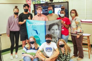 Photo of Duval Teacher of the Year, Jim Schmitt, posing in classroom with students after learning he was a Florida Teacher of the Year finalist