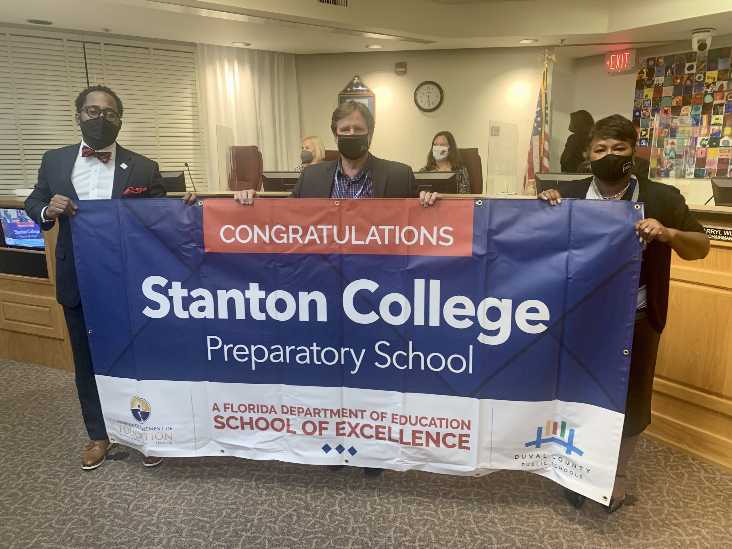 Superintendent, Board Chairman and school administrator hold banner Congratulations Stanton College Preparatory School a Florida Department of Education School of Excellence