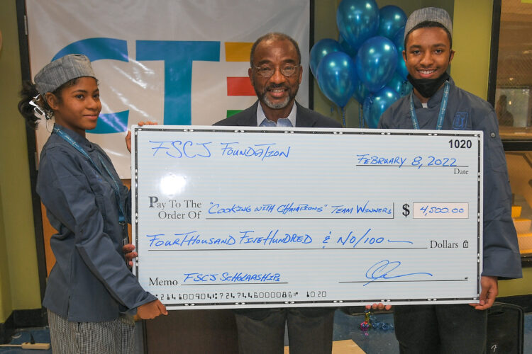 Winners of competition pose with giant check