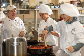Teacher and students in Frank H. Peterson culinary academy prepare a meal