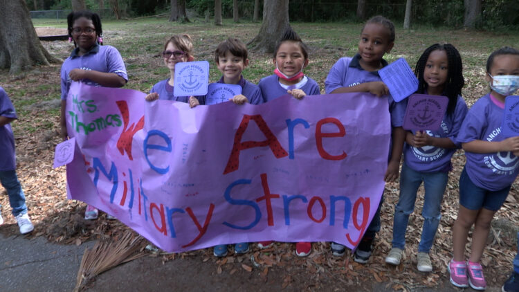 Anchor Academy students holding up a banner that reads "We are Military Strong"