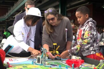 Teacher and students building a robot.