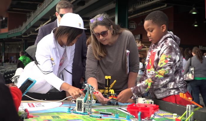 Teacher and students building a robot.