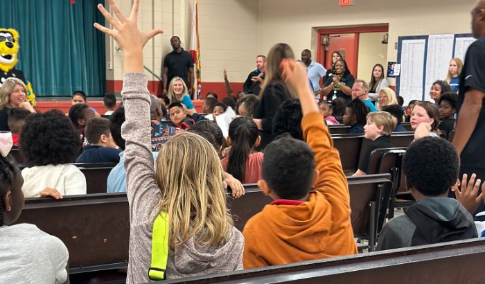 Spring Park Elementary students raise their hands during the "JA in a Day" assembly.