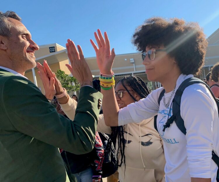 Principal George gives students a high five as they congratulate him.