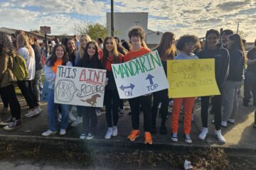 Students holding signs and cheering on the football team as they head to the state championship game.