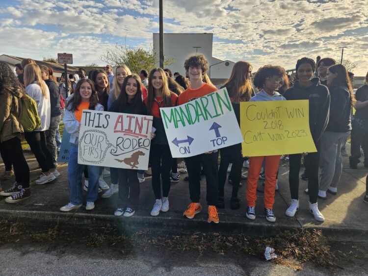 Students holding signs and cheering on the football team as they head to the state championship game.