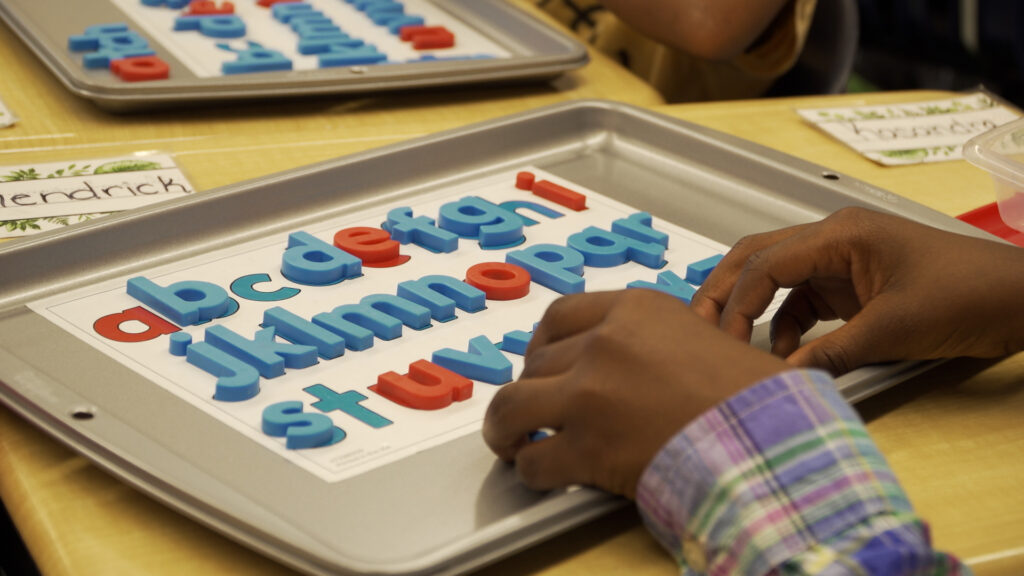 Elementary students learn to read using letter boards in class